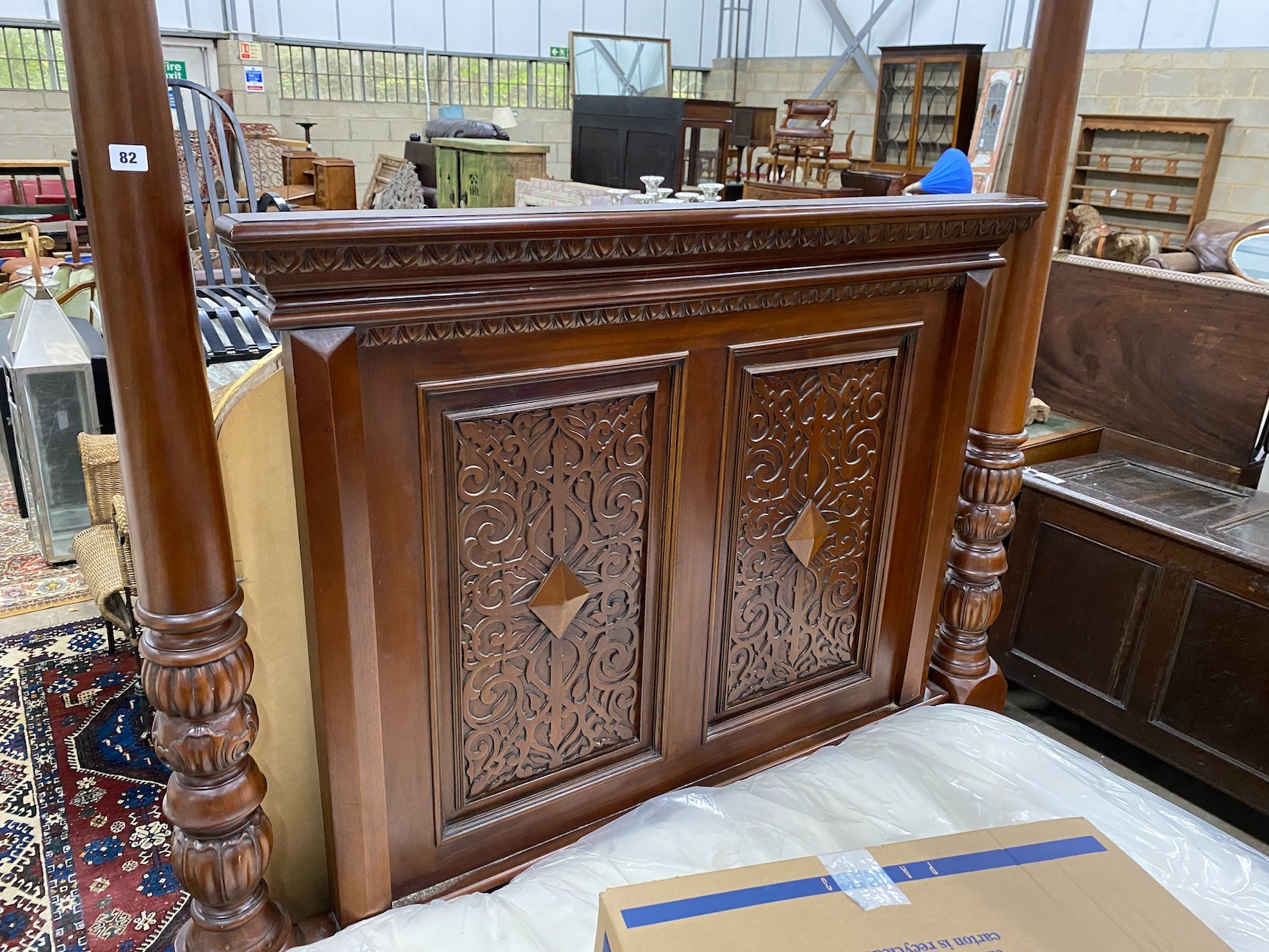 A reproduction carved mahogany four poster double bed frame with Visprung Lynton mattress, width 150cm, length 210cm, height 218cm